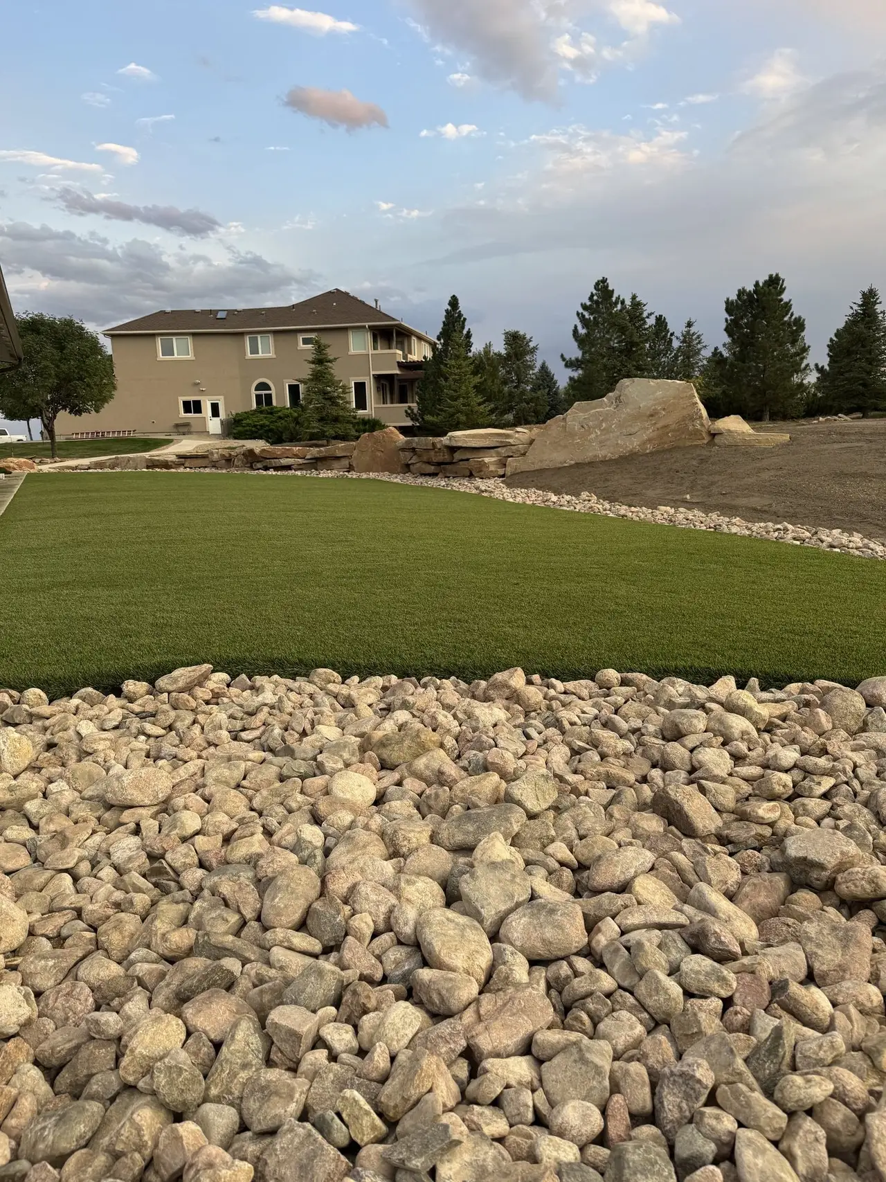 The edge where artificial turf meets a rock border, held tight and straight